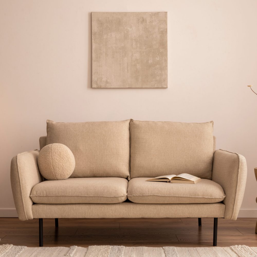 Creative composition of living room interior with mock up poster frame, beige sofa, round coffee table, vase with dried flowers, rug, rattan commode and personal accessories. Home decor. Template.